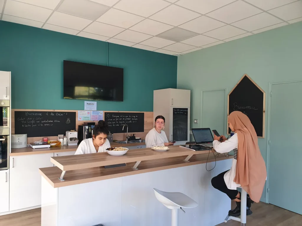 Des personnes travaillent autour du comptoir de la cuisine de La Coloc’