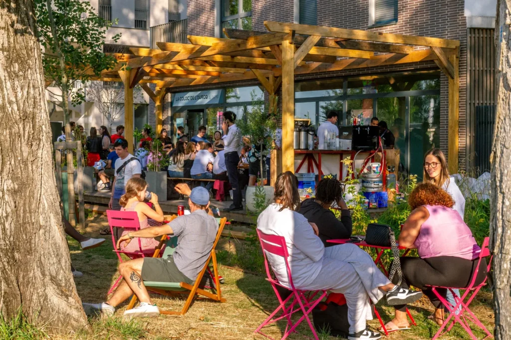 Des habitants et participants réunis dans le jardin de La Coloc’